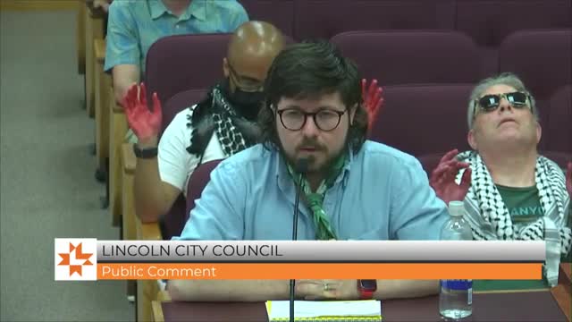 Activist confronts city leaders over funding for weapons manufacturer