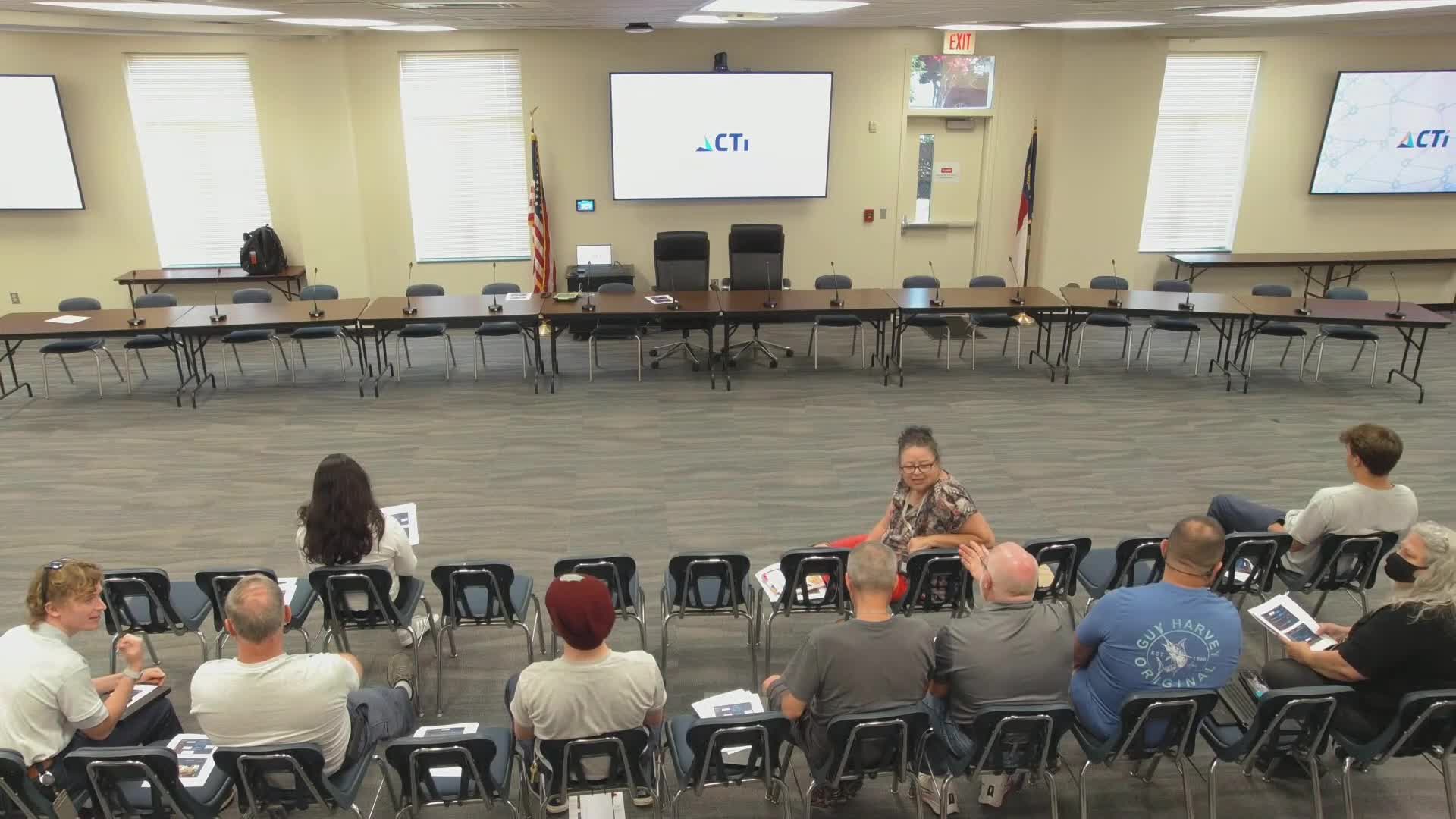 Staff discuss meeting-room AV setup, scheduling and video upload delays