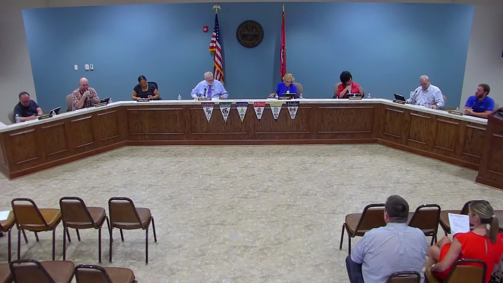 Director reports state compliance, coach compensation plan, enrollment shifts and test-score previews