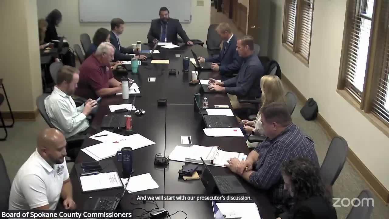 Prosecutor urges board to protect attorney headcount and fund technology upgrades; asks county to absorb interpreter fees