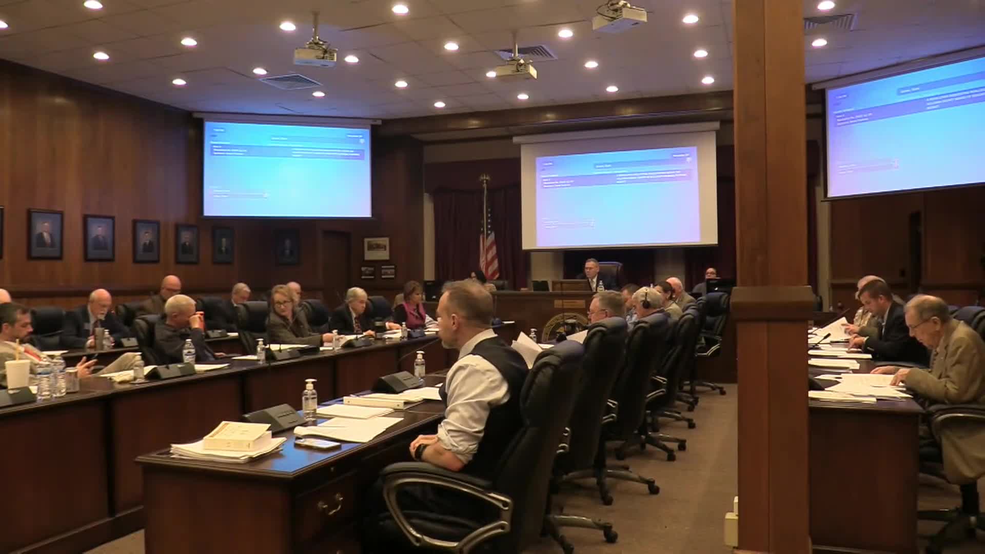 Commissioners send school maintenance reallocation to first reading after debate over contracts and costs