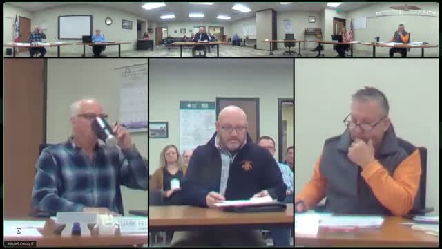 Mitchell County approves HMA project closeouts and reviews county‑line bid; engineer eyes used six‑way dozer